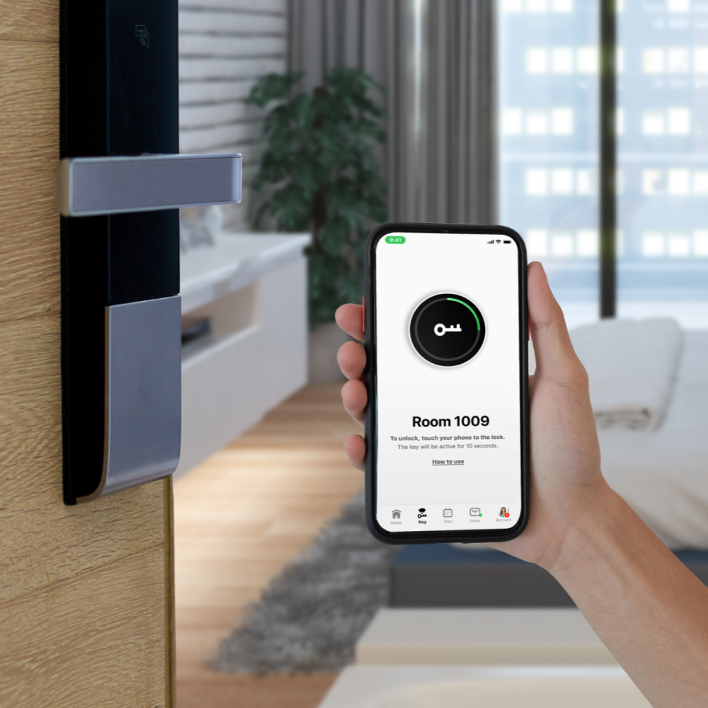 Open hotel room with mobile key on phone in hand and smart lock